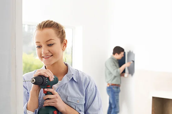 Person bohrt mit Akkuschrauber in Wand