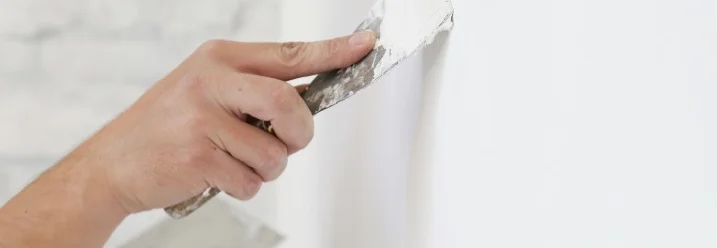 Hand spachtelt eine Wand