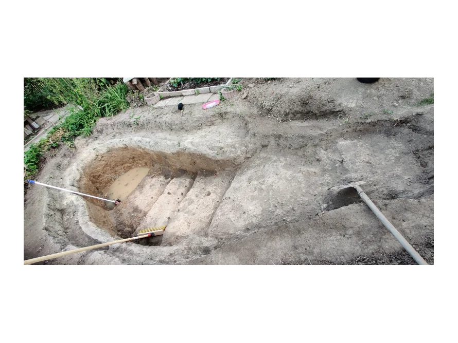 Teich im Bau mit Schaufel und Besen