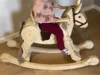 Kleinkind auf einem Schaukelpferd aus Holz