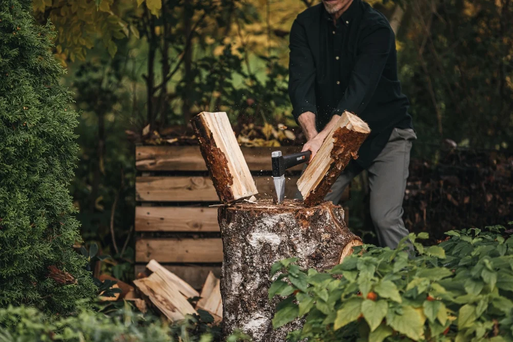 Person hackt Holz mit Axt