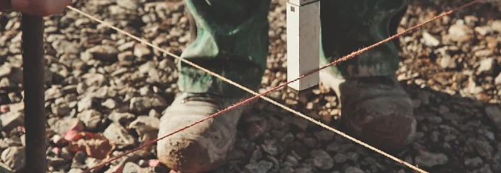 Person richtet Schnur mit Wasserwaage aus