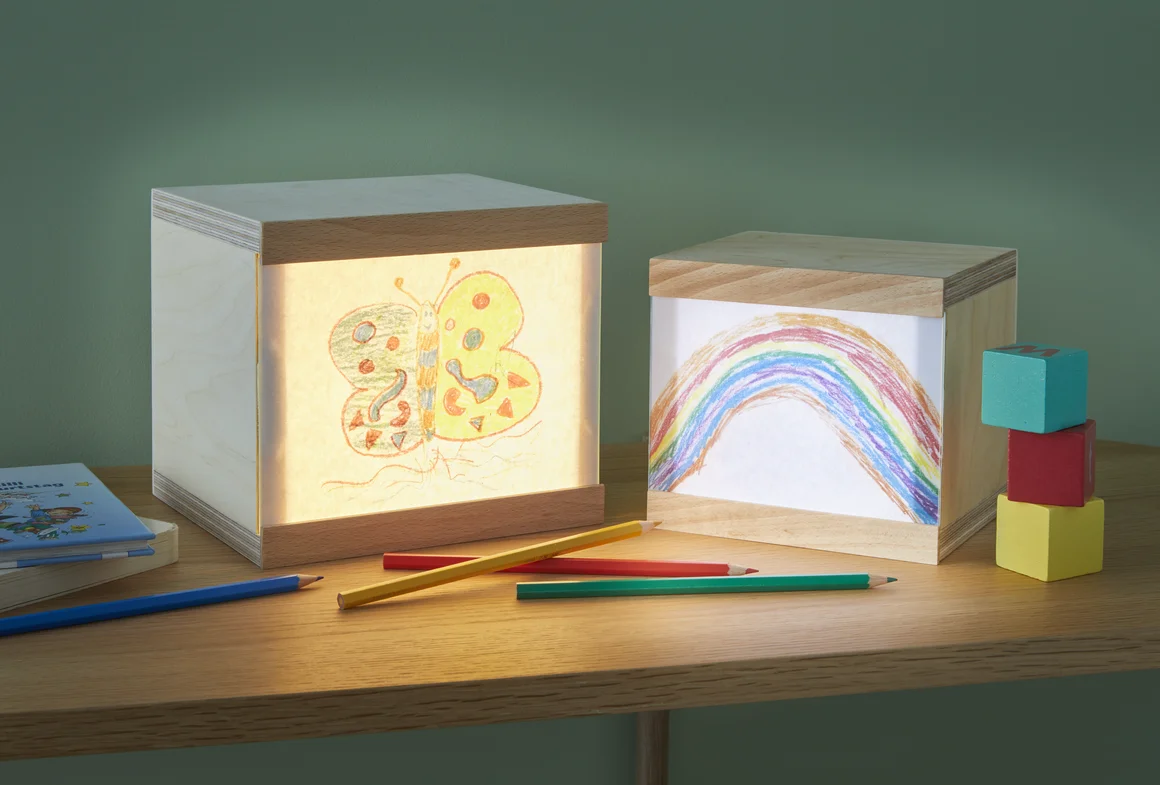 Zwei beleuchtete Holzkästen mit Kinderzeichnungen