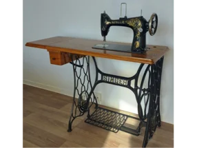 Eine alte Nähmaschine auf einem Holztisch.