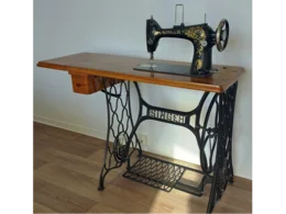 Eine alte Nähmaschine auf einem Holztisch.
