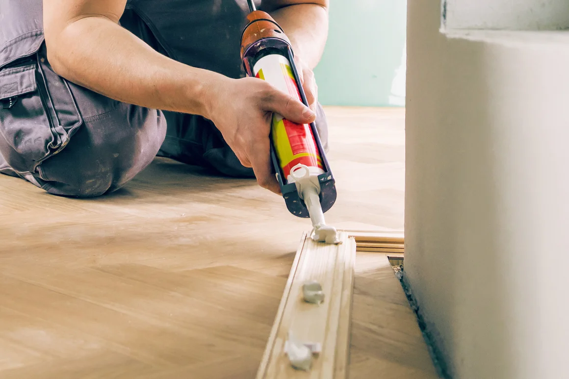 Person trägt Dichtmasse auf