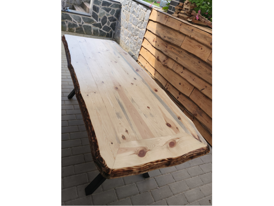 Holztisch mit Baumkante auf Fliesenboden