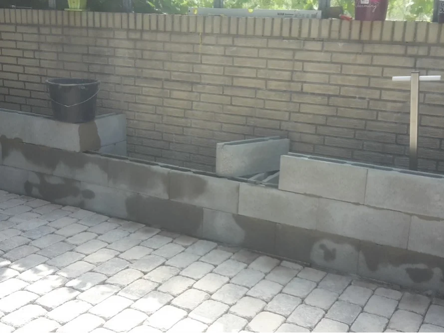 Eine halbfertige Mauer aus Betonblöcken.