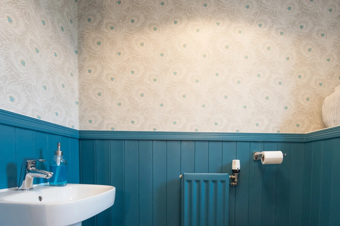 Stilvolles Badezimmer mit blauer Wandverkleidung