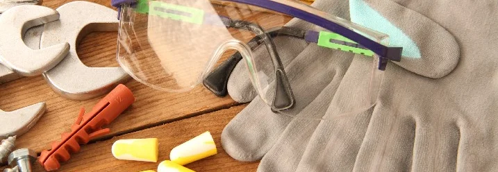 Werkzeug und Sicherheitsausrüstung auf Holz