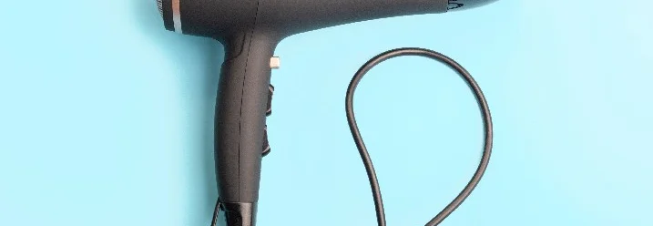 Ein schwarzer Haartrockner auf blauem Hintergrund.
