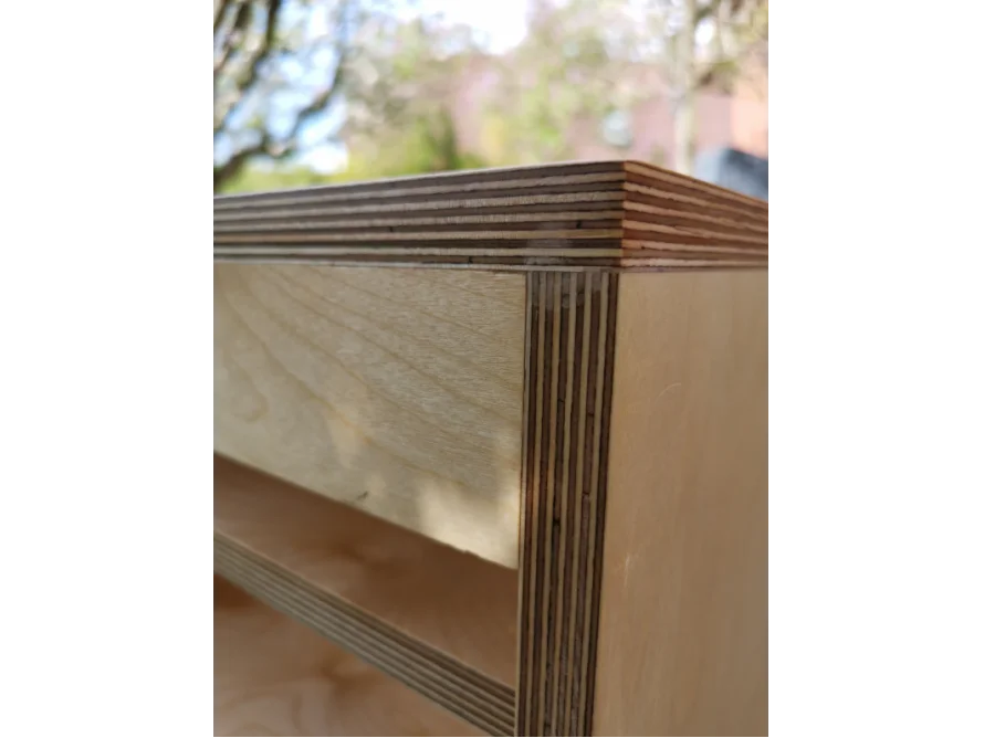 Nahaufnahme: Ecke eines Möbelstücks aus hellem Holz.