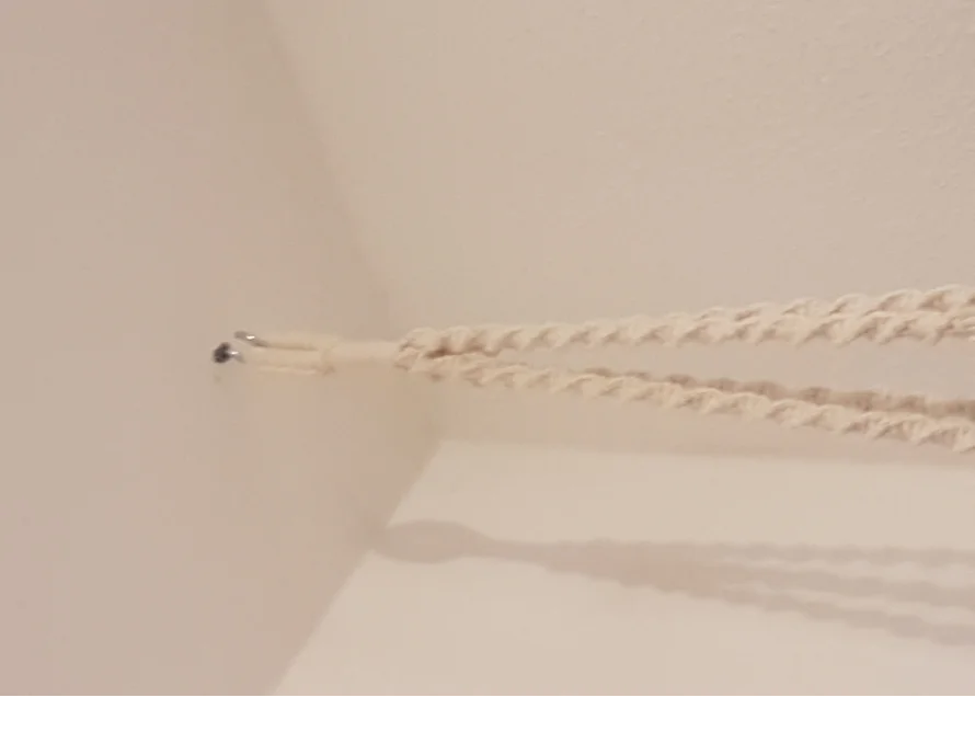 Verdrehte Aufhängeschnur an Haken