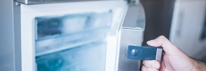 Hand öffnet Gefrierschrank