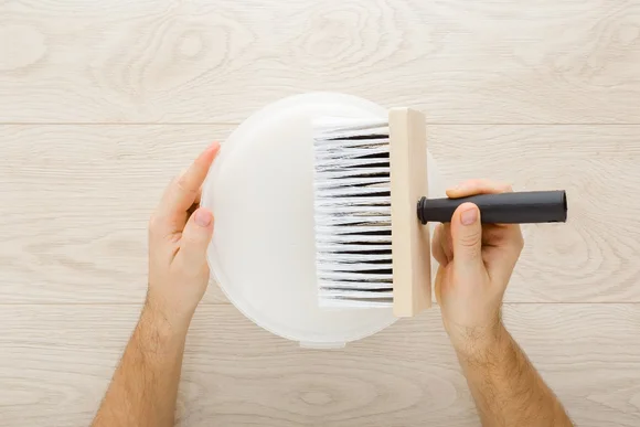 Hände halten Eimer und Tapezierbürste