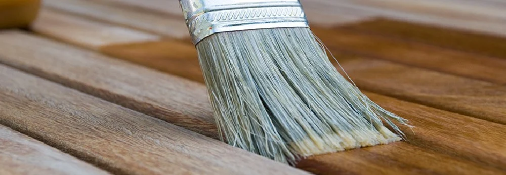 Pinsel trägt Lasur auf Holz auf