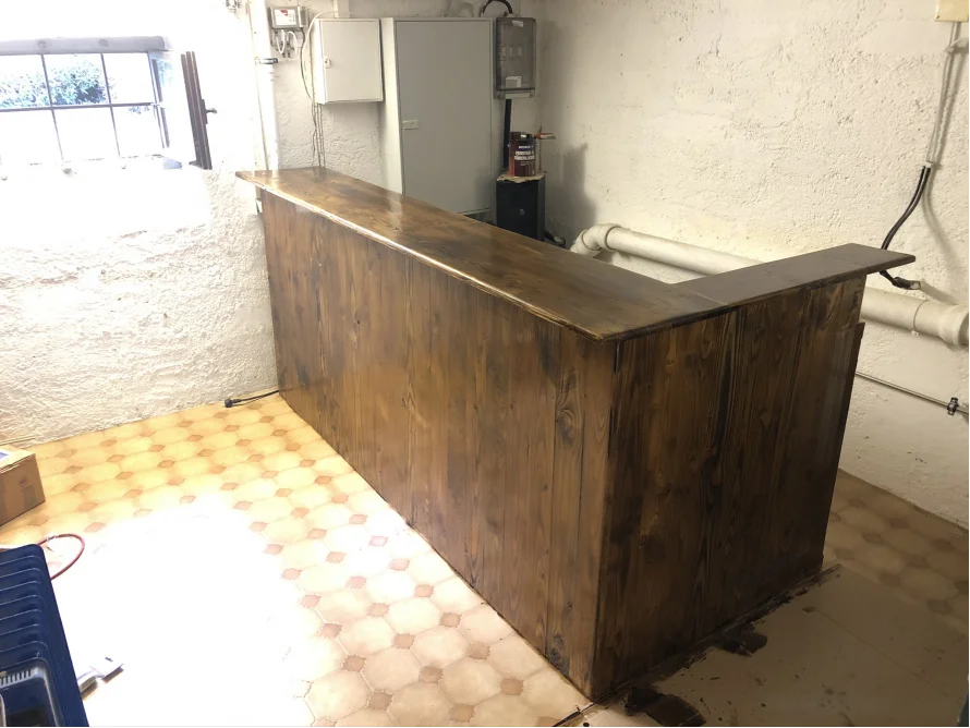 Dunkel gebeizte Holztheke in einer Ecke