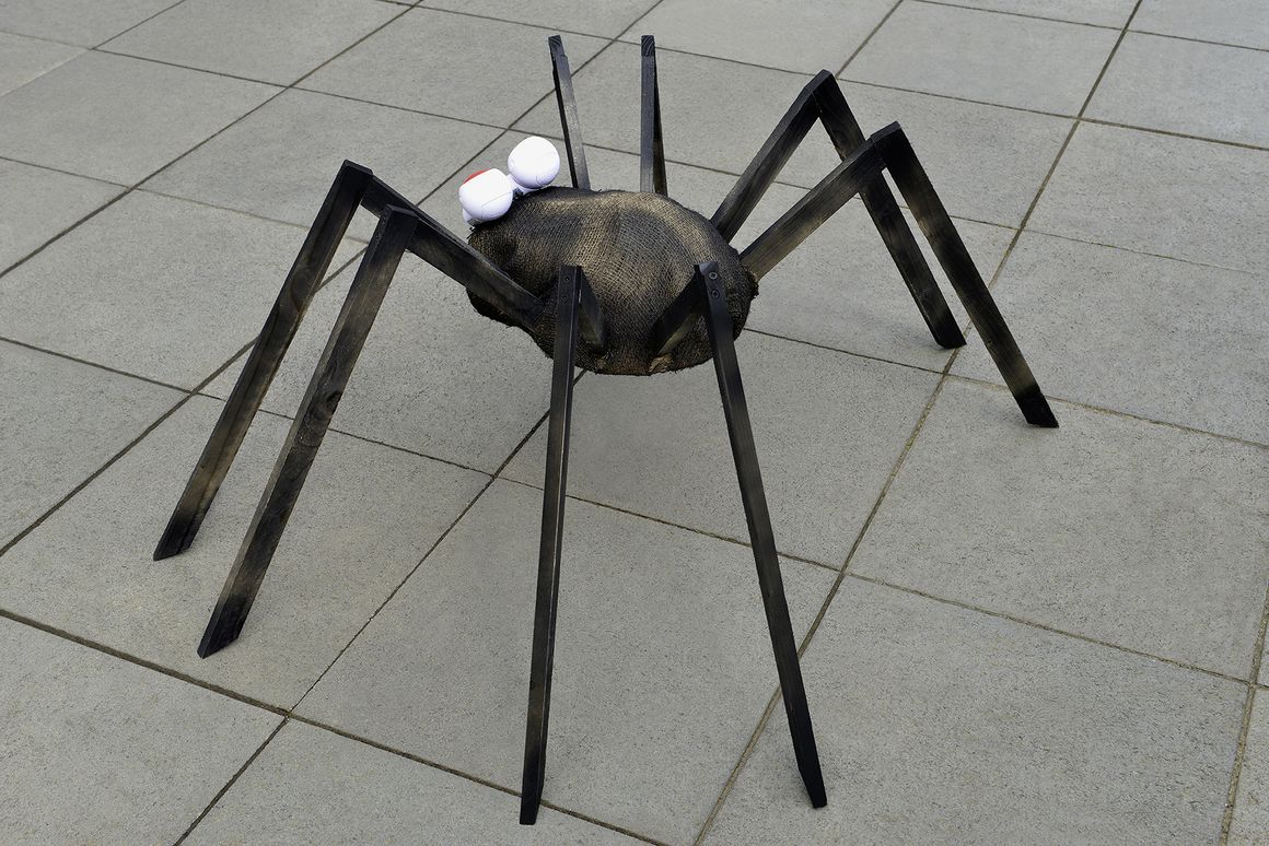 Spinne aus Holz auf Gehweg