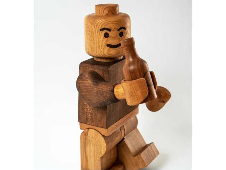 Eine Holzfigur hält eine Flasche