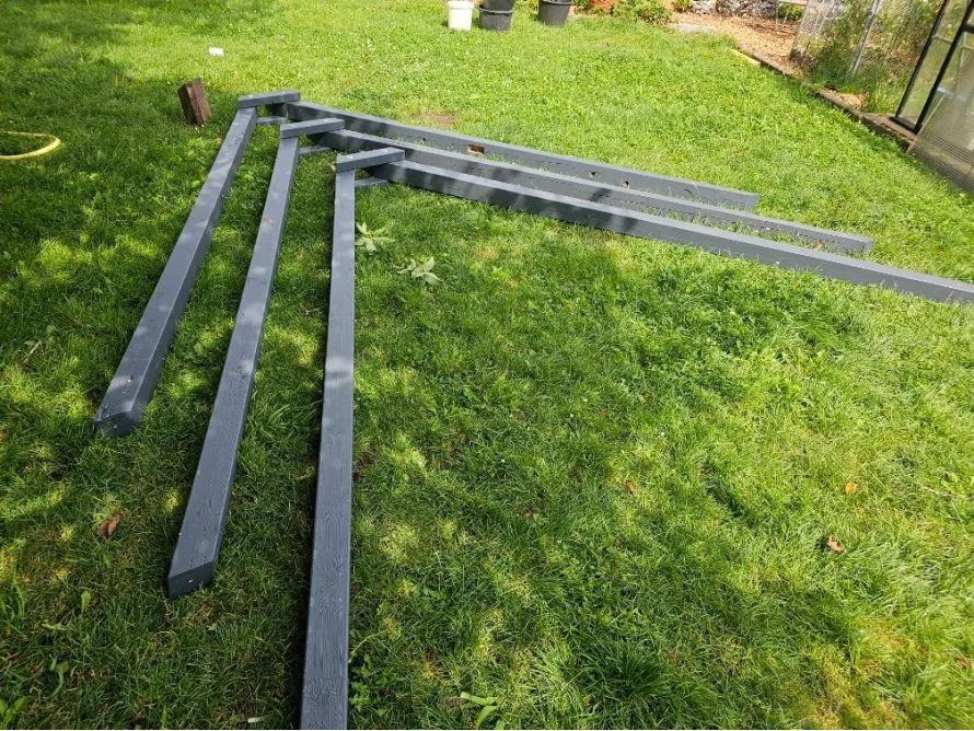 Vier graue Holzbalken auf Rasen