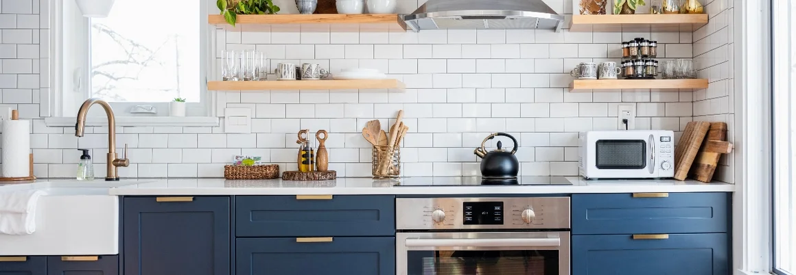 Moderne Küche mit blauen Schränken und offenen Regalen.