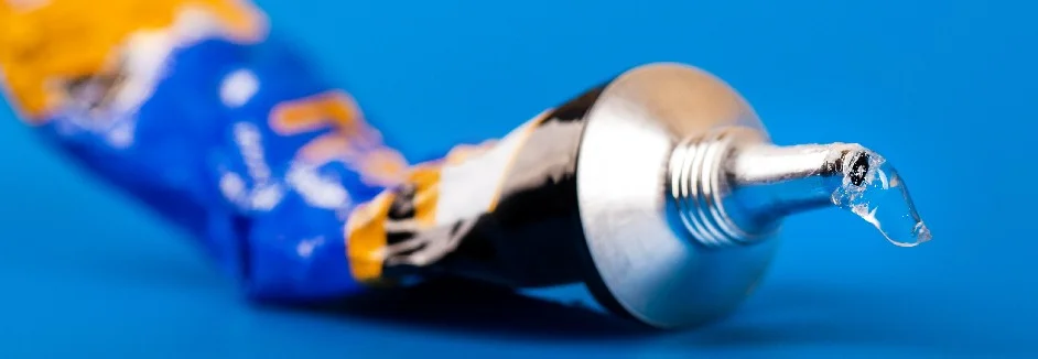 Tube Klebstoff auf blauem Hintergrund