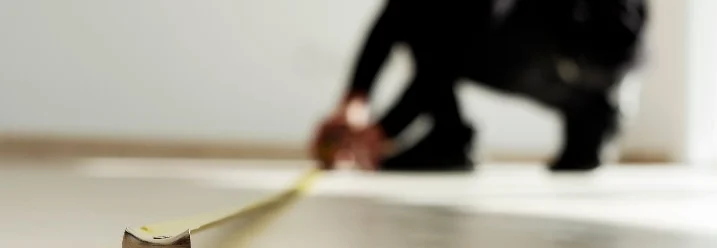 Person misst Boden mit Zollstock