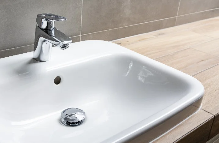 Ein weißes Waschbecken mit einem Wasserhahn.