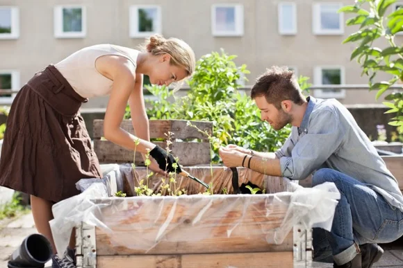 Zwei Personen beim Gärtnern mit einer Harke