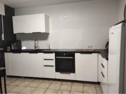 Moderne Küche mit weißen Schränken und schwarzen Arbeitsplatten