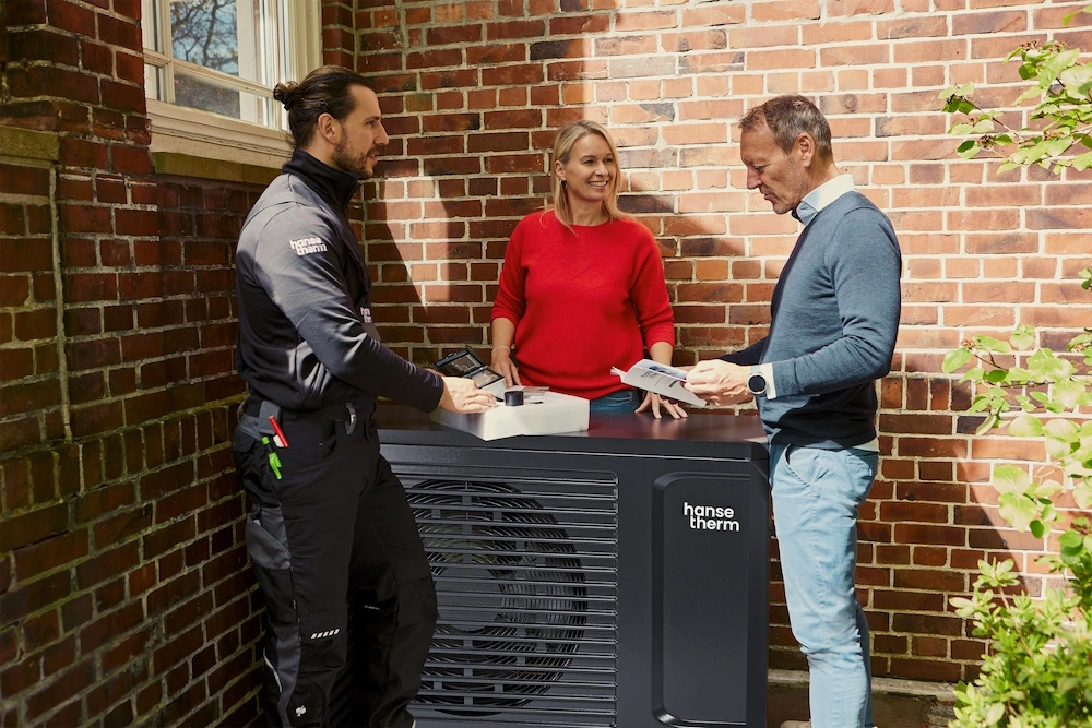 Drei Personen stehen an einer hansetherm Wärmepumpe