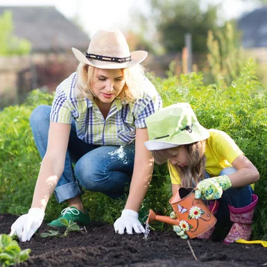 Person und Kind pflanzen mit Gießkanne