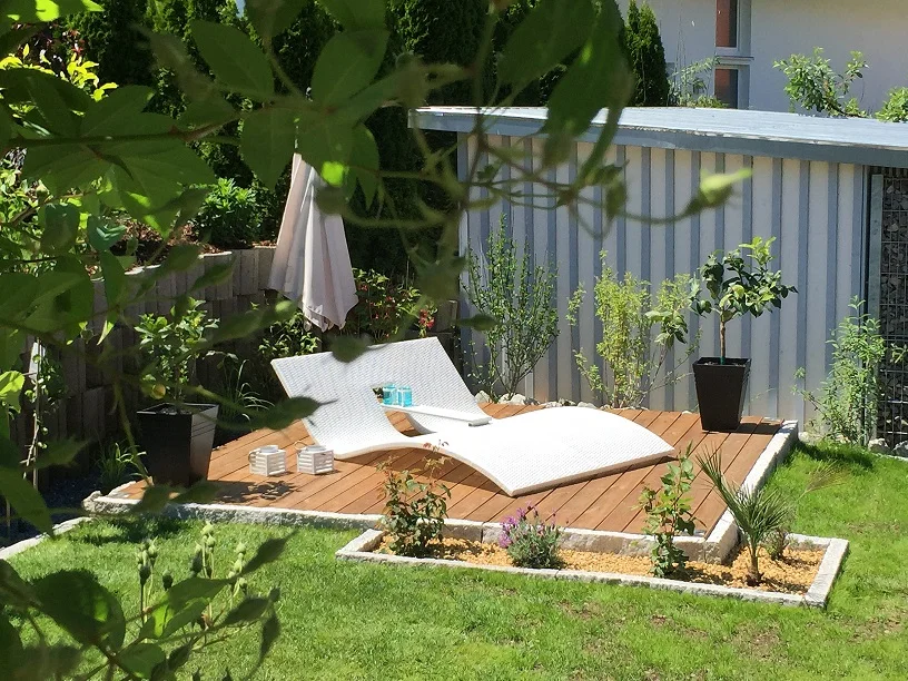 Holzterrasse mit Liege im Garten