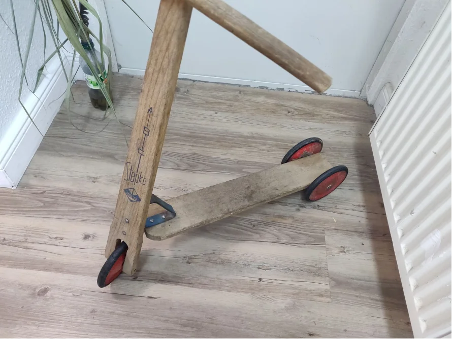 Hölzerner Kinderroller auf einem Holzboden.