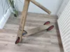 Hölzerner Kinderroller auf einem Holzboden.