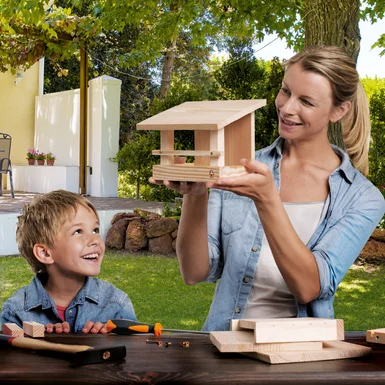 Person und Kind bauen ein Vogelhaus