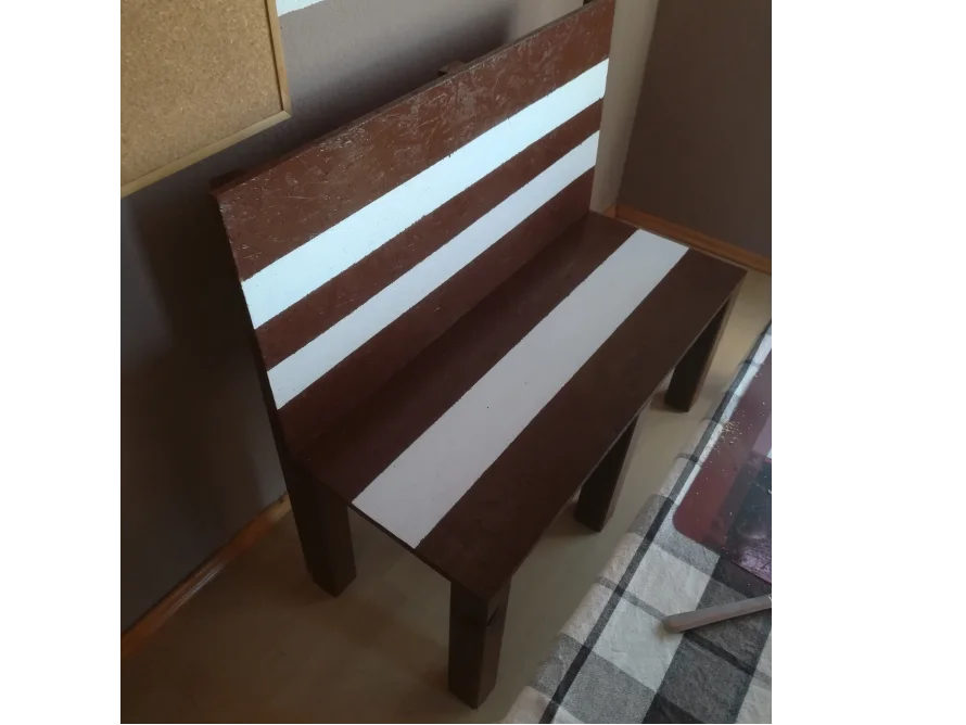 Braune Holzbank mit weißen Streifen