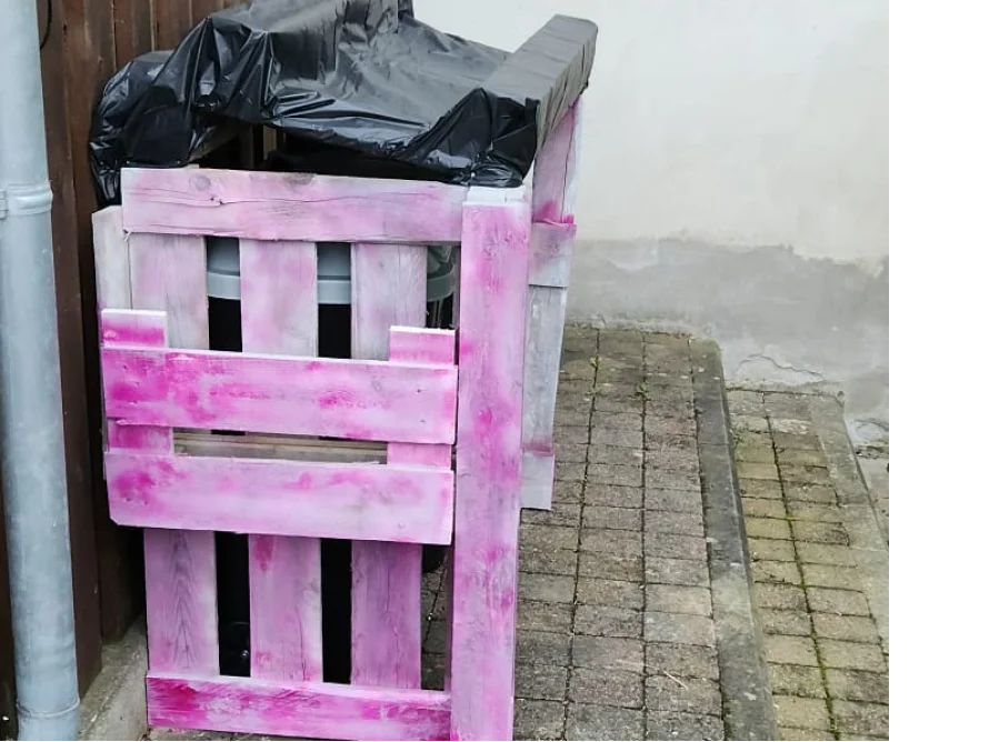 Rosafarbener Mülltonnenverkleidung aus Paletten