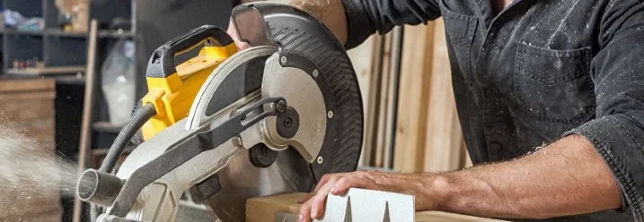 Person sägt Holz mit Kreissäge