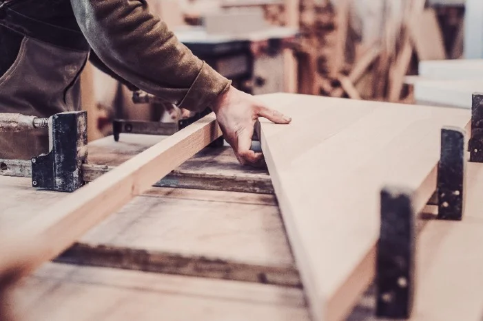 Person baut Holzrahmen mit Schraubzwingen