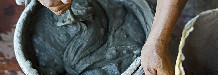 Person mischt Zement in Eimer