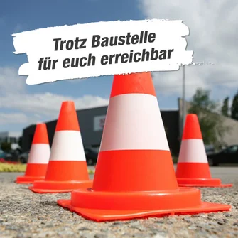 Mehrere orangefarbene Leitkegel auf einem Parkplatz