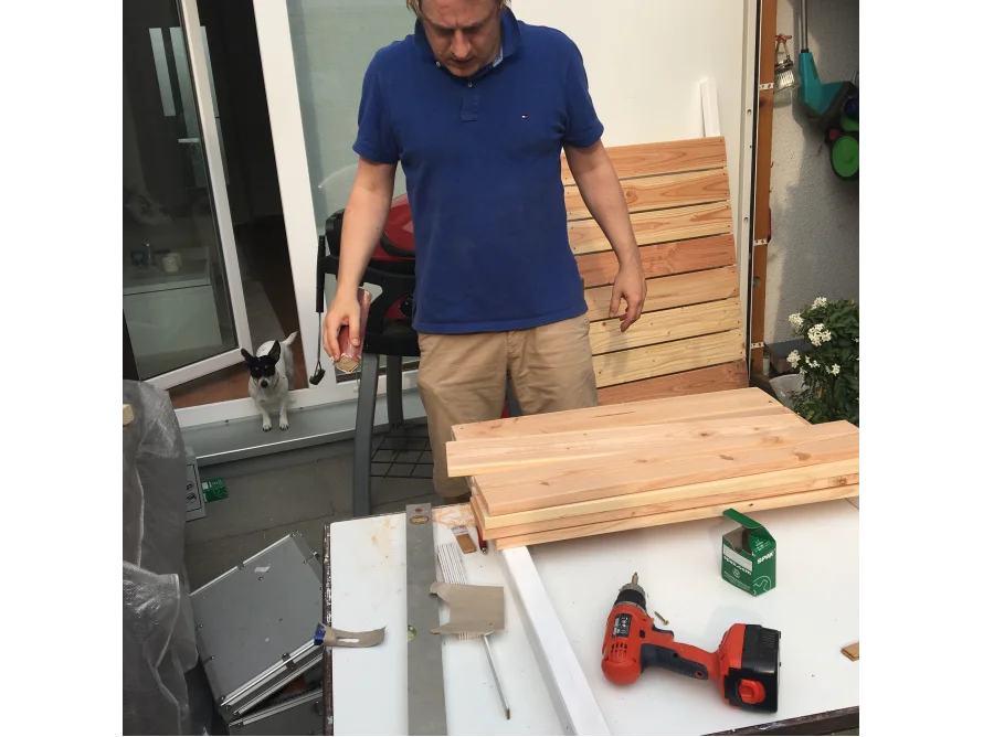 Person baut mit Akkuschrauber Holzlatten zusammen