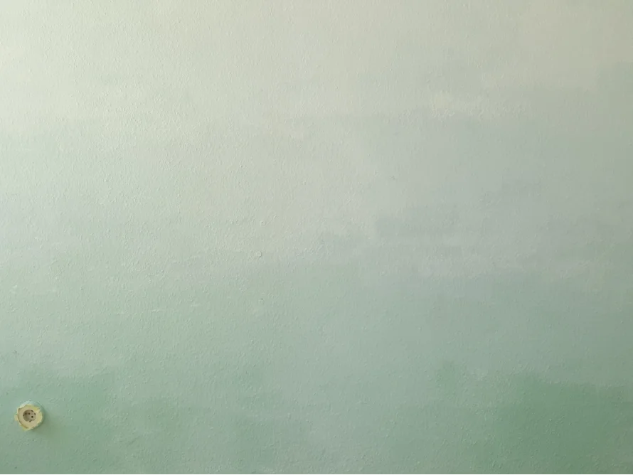 Verwaschen grün gestrichene Wand
