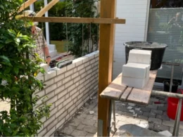 Person mauert eine weiße Ziegelwand