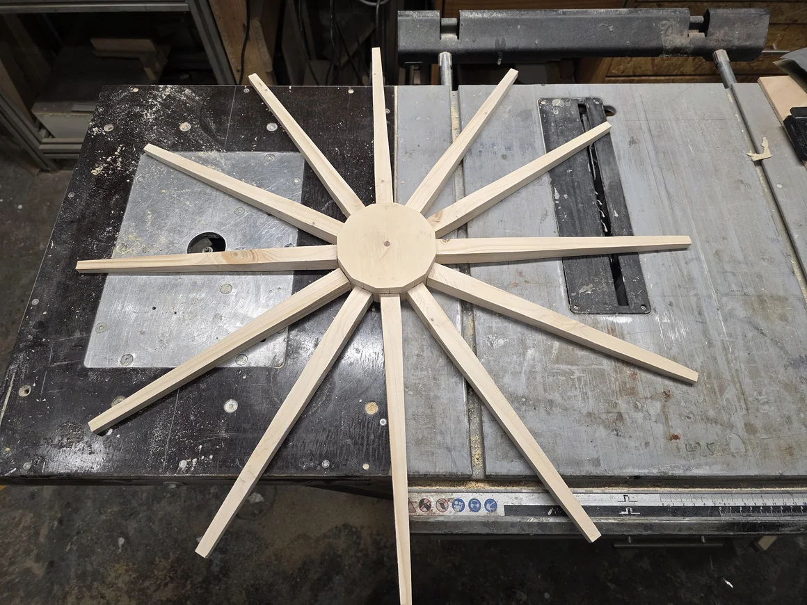 Ein bearbeitetes, polygonales Holzstück mit Löchern liegt auf einer Tischkreissäge.