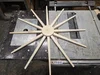 Ein bearbeitetes, polygonales Holzstück mit Löchern liegt auf einer Tischkreissäge.