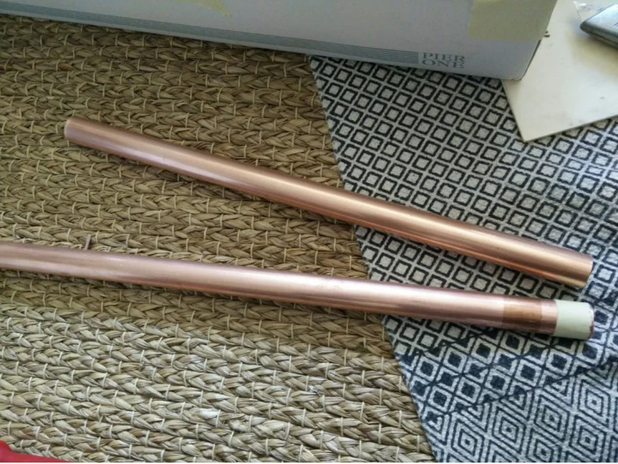 Zwei Kupferrohre auf einem Teppich.