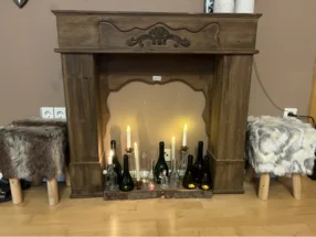 Kaminattrappe mit Kerzen und Flaschen