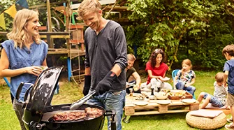 Person gibt Gegrilltes mit Grillzange auf Teller